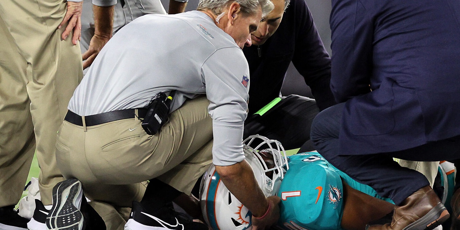 A dophins player being treated on the field after an injury